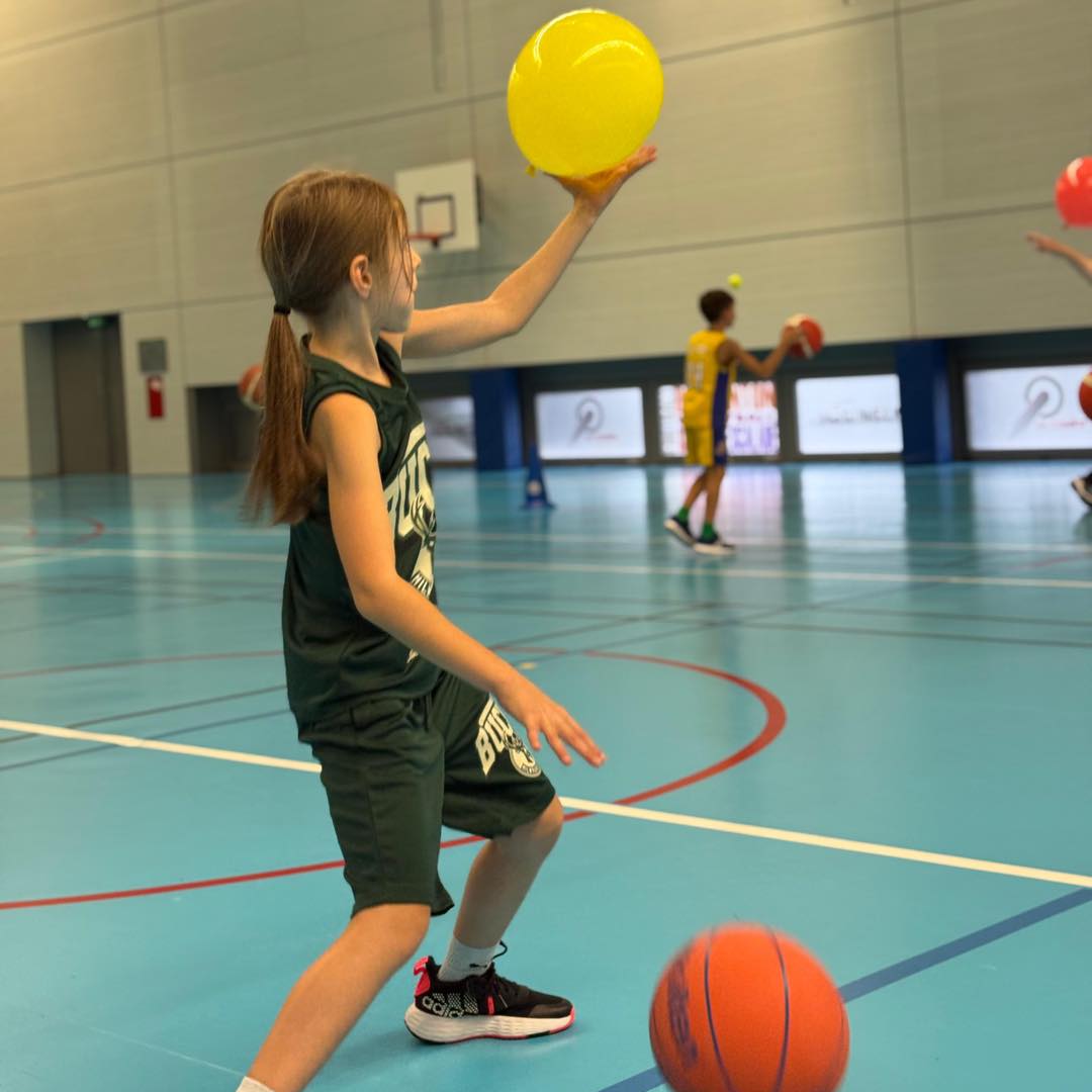 Une participante réalise un atelier de coordination avec ballon.