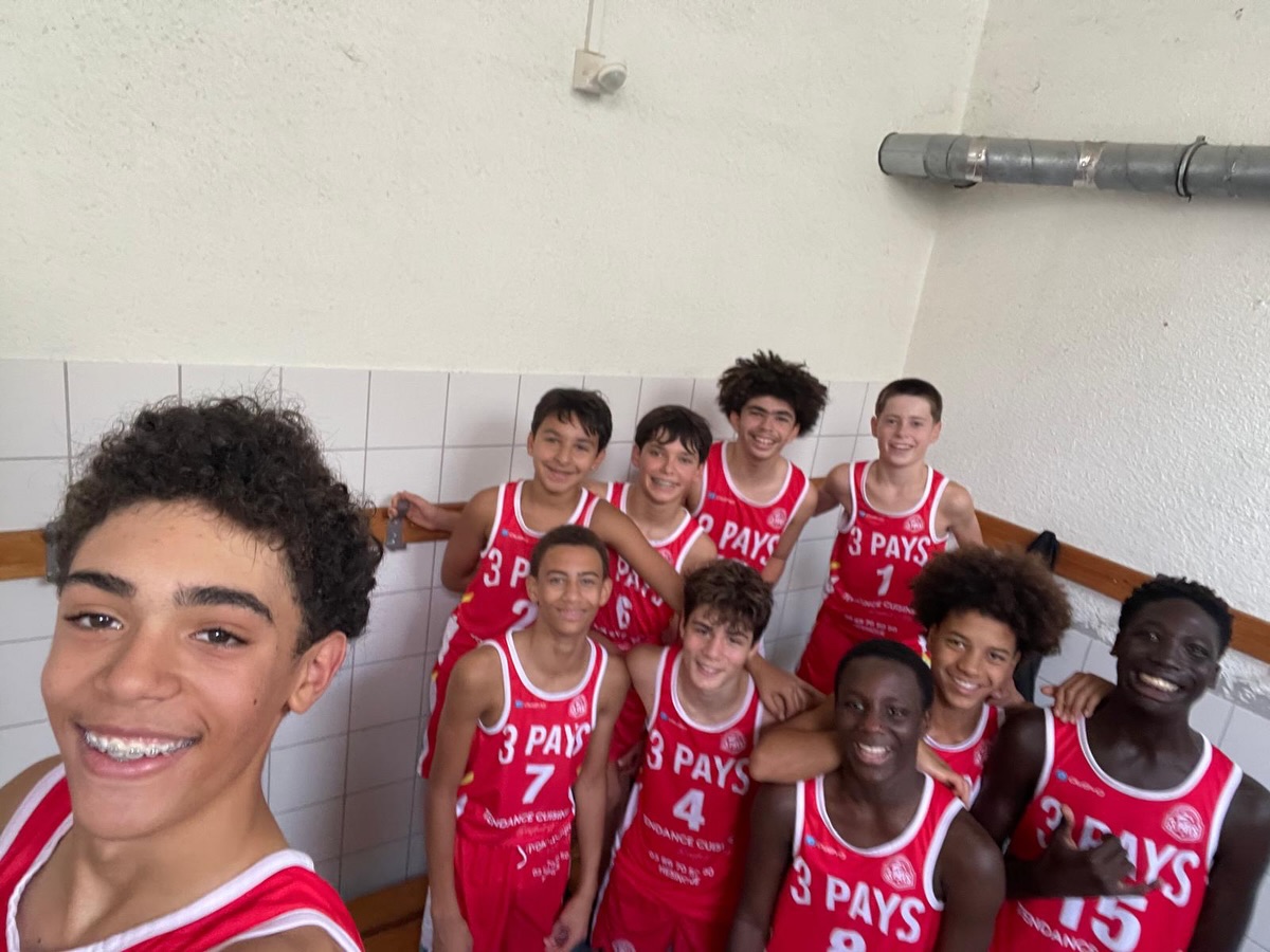 Selfie collectif de jeunes basketteurs du club en maillots rouges.
