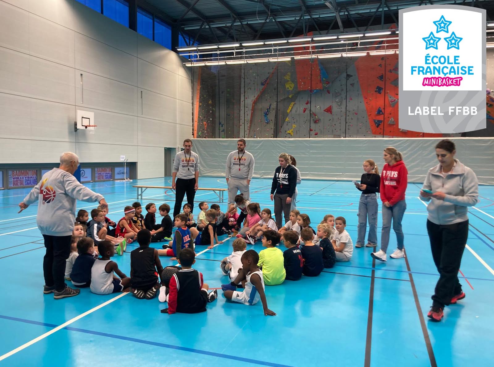 Enfants et encadrants réunis au gymnase pendant une séance ; le badge École Française de MiniBasket figure sur la publication.